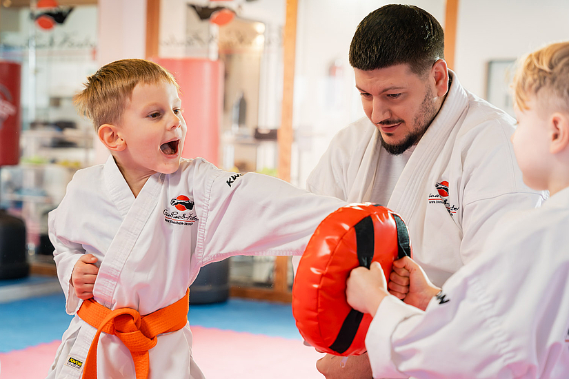 Heller Trainingsraum mit Kindern und Karatelehrer beim Karateunterricht Heller Trainingsraum mit Kindern und Karatelehrer beim Karateunterricht