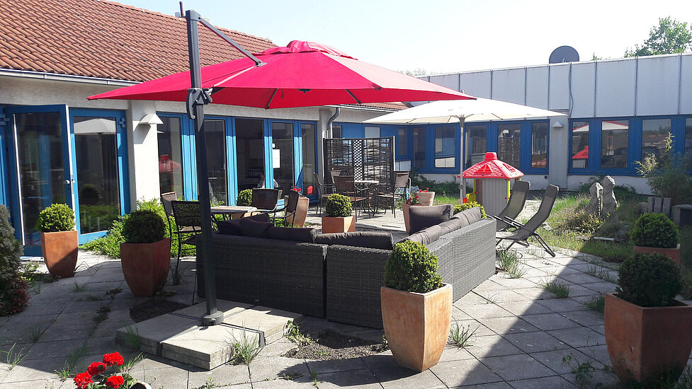 Eltern sitzen auf der Terrasse mit Blick auf das Karatetraining der Kinder