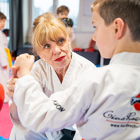 Motivierte Kinder trainieren Karate gemeinsam mit ihrem Lehrer
