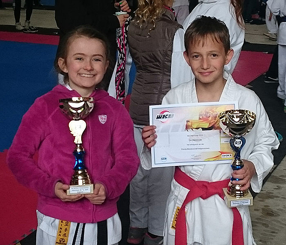 Zwei kleine Helden halten stolz errungen Pokale